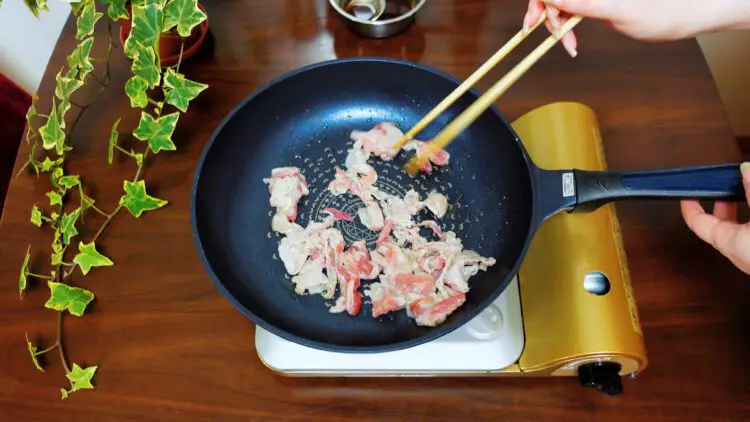 Separate the meat slices on the pan and fry them until half way