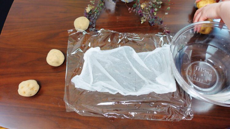 soak a paper towel in water and then lay it on the plastic wrap