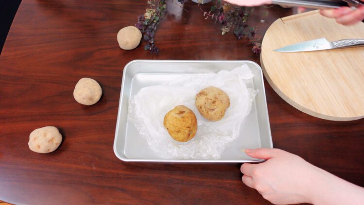 take potatoes out of the microwave oven and remove the plastic wrap and the paper towel