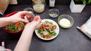 sprinkle some seeds, Parmigiano Reggiano, and pink peppercorns over the salad