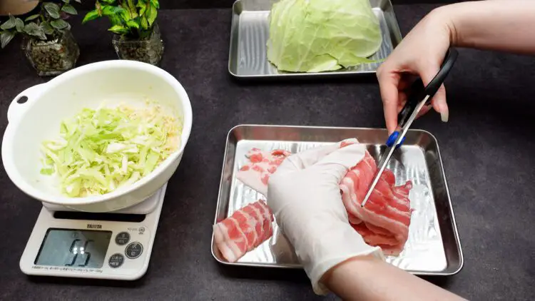chopping pork belly slices with scissors