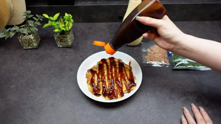 cover the top of the pancake with okonomiyaki sauce