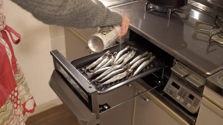 Lay the fish over the grill and spray oil on the top of the fish