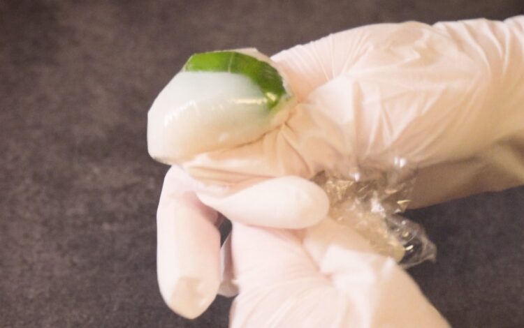 making Squid sushi with a piece of basil leaf