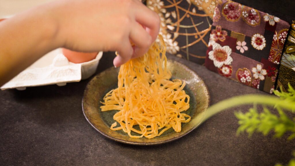touching kinshi tamago with a hand