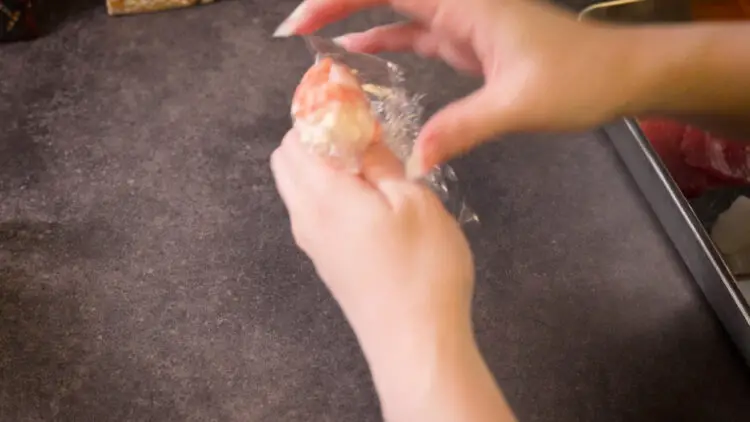 wrap the layer of toppings around the keto rice using the plastic wrap