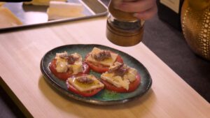 sprinkling ground black pepper on the canape