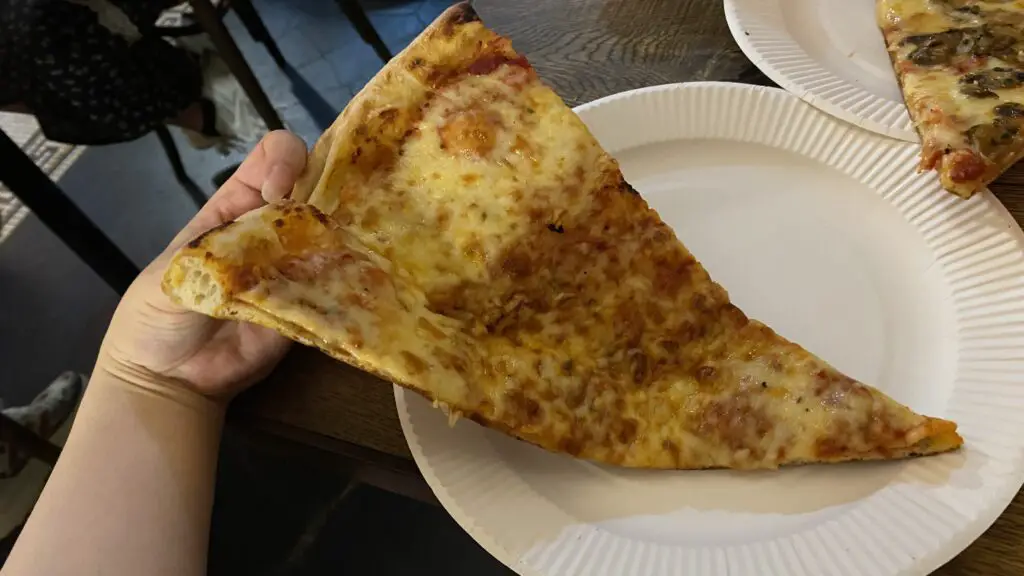 Grabbing a pizza slice in hand