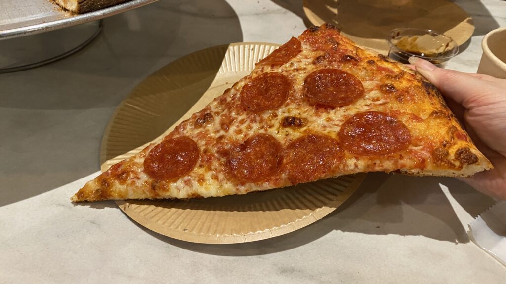 Holding a pepperoni slice in hand
