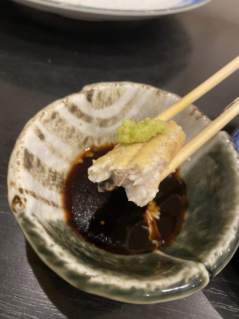dipping shirayaki into soy sauce