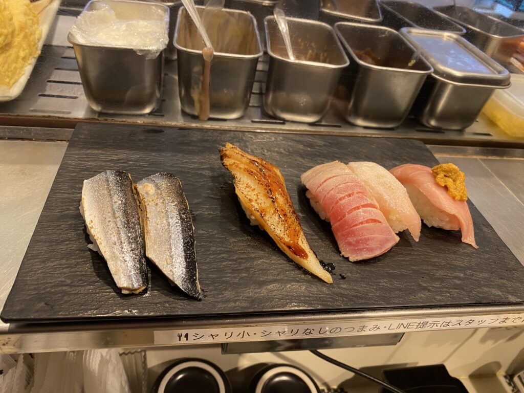 several pieces of sushi on the counter at Standing Sushi Bar UOGASHI NIHON-ICHI
